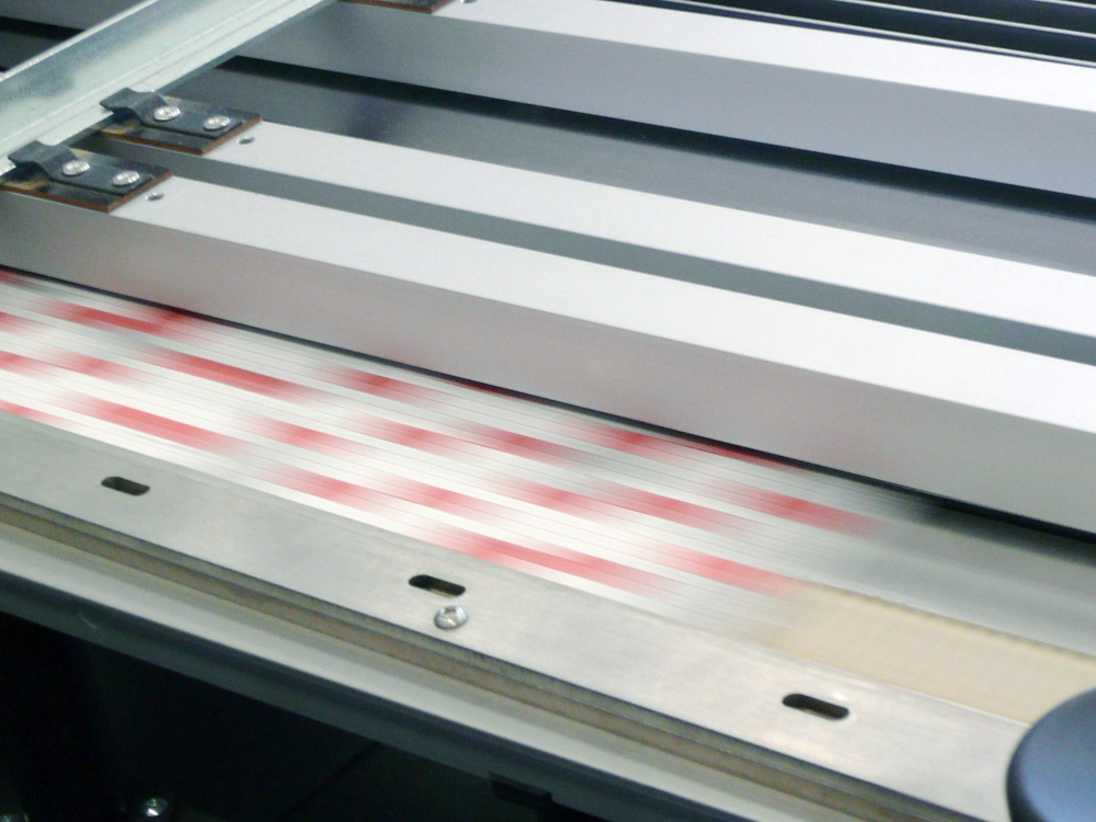 Medientechnologe Druckverarbeitung - In einer hohen Geschwindigkeit laufen die Falzbogen durch die Falzmaschine.