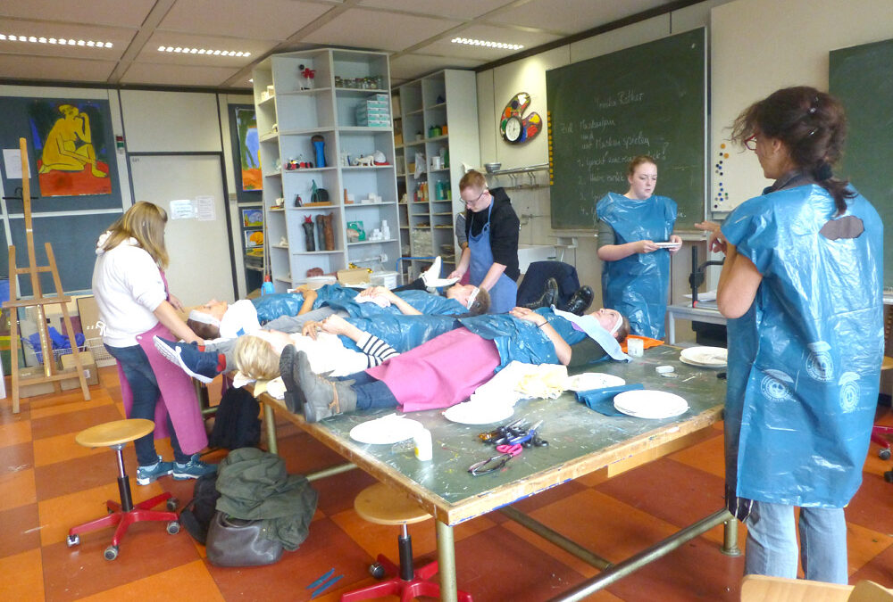 1. Blick in den „Operationssaal Kunstraum“: Von den Gesichtern der SchülerInnen wird eine Gips-Maske aus Gipsbinden abgeformt.